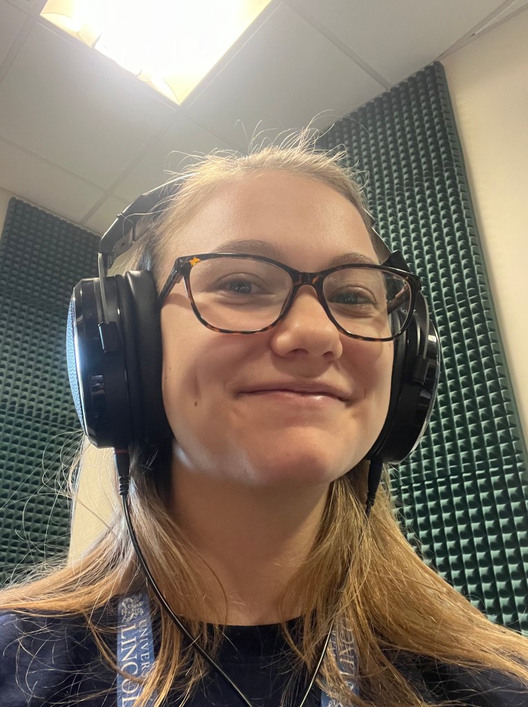 Kara wearing a headset at a radio station.